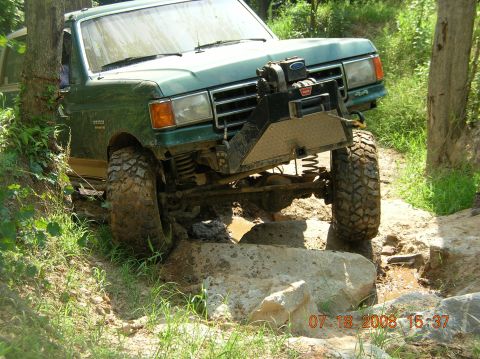 1991 Ford F-150 - Off-road Bronco tackles a challenging obstacle course with large tires and a winch.