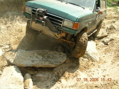 1991 Ford F-150 - Green truck with winch on front bumper navigating rocky terrain.