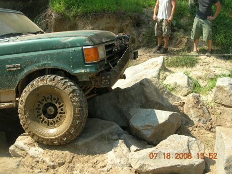 1991 Ford F-150 - A green Bronco navigates a rocky trail with two people watching.
