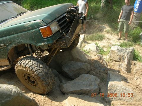 1991 Ford F-150 - A green 1991 Ford F-150 navigates a rocky obstacle course with a winch attached.