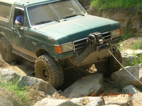 1991 Ford F-150 - This 1991 Ford Bronco navigates a challenging rocky terrain, equipped with a front-mounted winch for assistance.