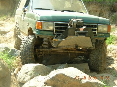 1991 Ford F-150 - This modified SUV is shown off-roading over rocks and dirt.