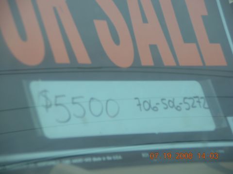 1991 Ford F-150 - A sign on a car window advertises a vehicle for sale with a price and contact number.