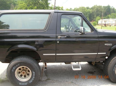 1991 Ford F-150 - Side view of a black SUV, identified by the "BRONCO" badge on the fender.