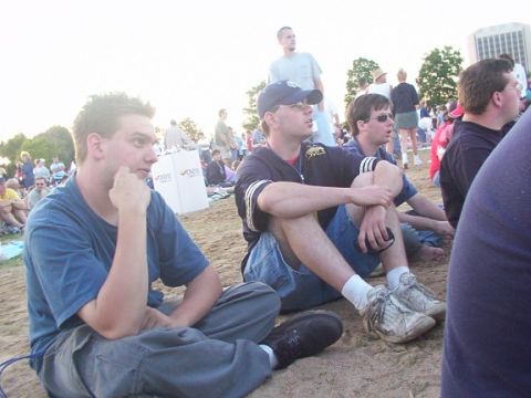 1998 Ford Taurus - People gathered outdoors, sitting on the ground at what appears to be an event or concert.