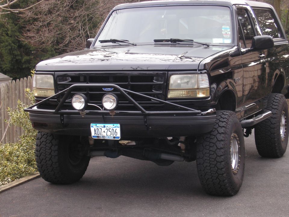 Front view of a black Ford Bronco with a custom bull bar and off-road tires. License plate ADZ-2506 is visible