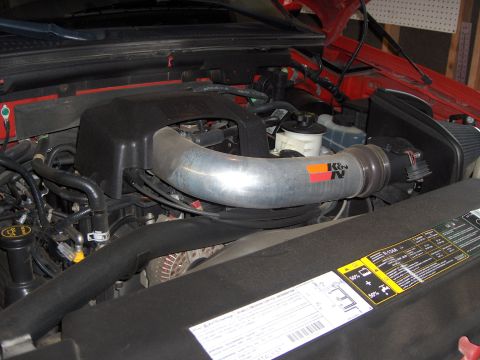 2007 Ford Mustang - Close-up view of an engine bay a K&N air intake system and various warning labels.