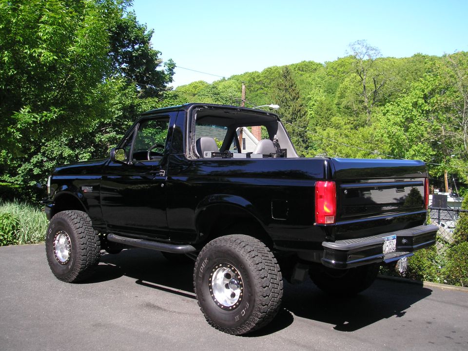 Black 1995 Ford Bronco with removable top, lifted suspension, and aftermarket wheels parked outdoors