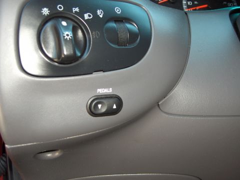 2007 Ford Mustang - Interior view of car controls, including headlight switch and power pedal adjustment button.