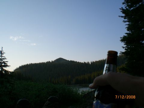 2004 Ford F-150 - A scenic view of a mountain and lake at dusk, with a hand holding a beer bottle in the foreground.