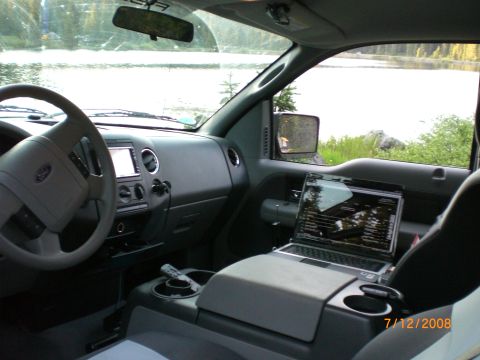 2004 Ford F-150 - Interior view of a pickup truck parked by a lake, with a laptop open on the center console.