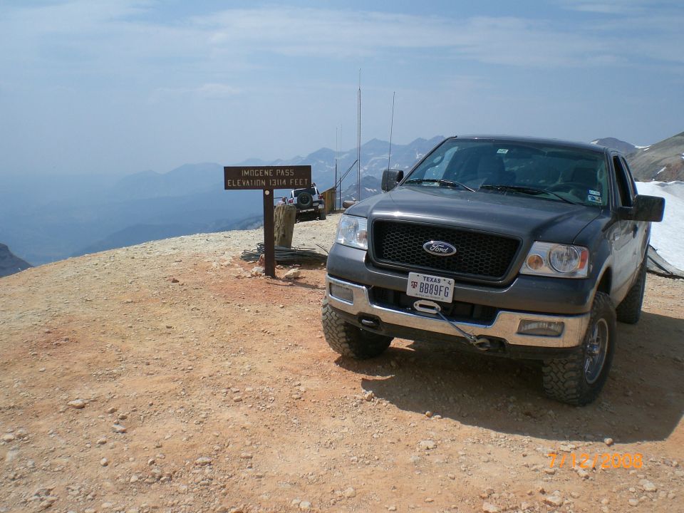Dark gray 2004 Ford F-150 truck parked on a dirt road with mountains in the background