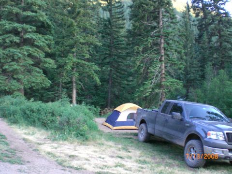 2004 Ford F-150 - A 2004 Ford F-150 is parked at a campsite with a tent set up in the woods.