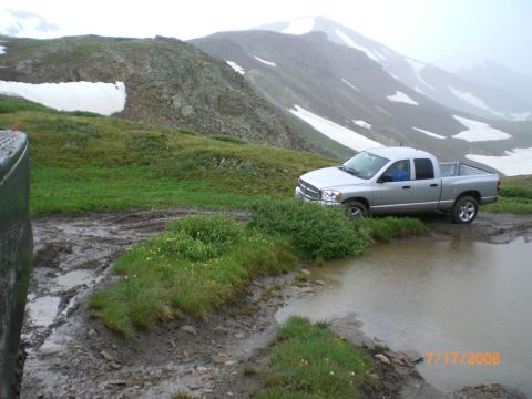 2004 Ford F-150 - A silver pickup truck is parked on a muddy mountain road, with snow-capped peaks in the background. The date stamp indicates July 17, 2008.