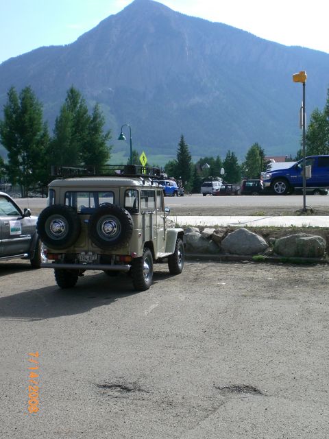 2004 Ford F-150 - This vintage Toyota Land Cruiser FJ40, seen from the rear, features dual spare tires and a roof rack, parked with a mountain backdrop.