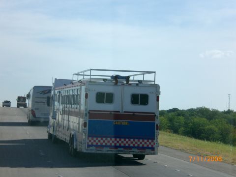 2004 Ford F-150 - Horse trailer with 'CAUTION' text seen on highway with other vehicles.