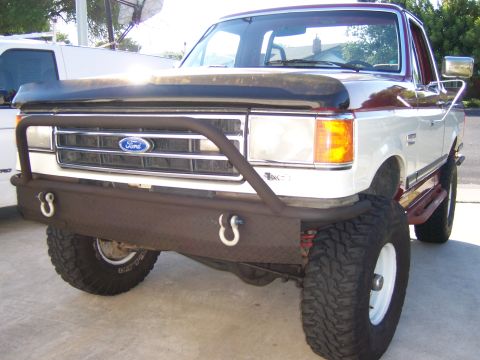 1991 Ford Bronco - This Ford truck features a custom diamond plate bumper with D-ring mounts and large off-road tires.
