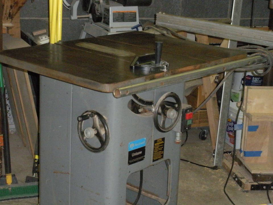 Unisaw table saw with two hand wheels and a blade guard