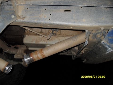 1990 Ford Bronco - Undercarriage view of a vehicle, showing the exhaust system and part of the drivetrain, including a driveshaft with a visible weld repair.…