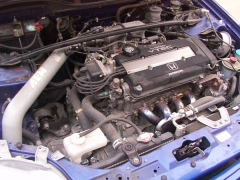 1998 Ford Taurus - Close-up of a Honda engine bay, the VTEC engine cover and an aftermarket intake.