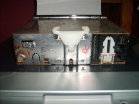 1993 Ford Crown Victoria - The rear of a car stereo unit is shown, featuring various connectors and some visible corrosion on the metal casing.