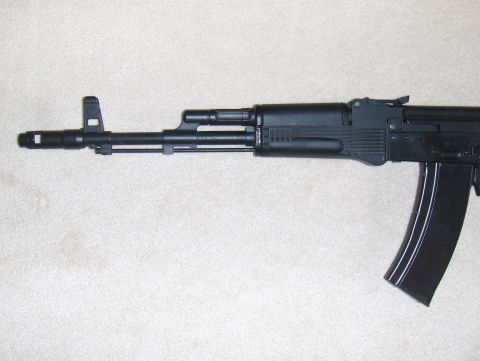 2003 Ford Crown Victoria - Close-up of an AK-47 rifle, showing the barrel, gas tube, and magazine.
