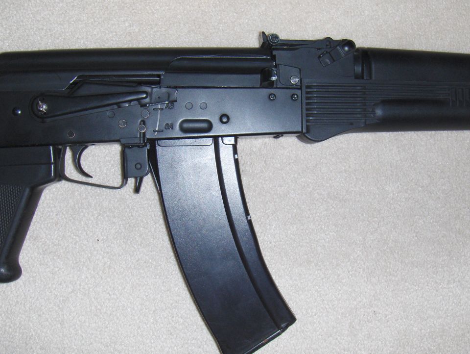 Close-up of an airsoft rifle, showing the receiver, trigger, and magazine
