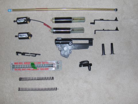 2003 Ford Crown Victoria - Various internal components for an airsoft gun are displayed on a carpeted surface.