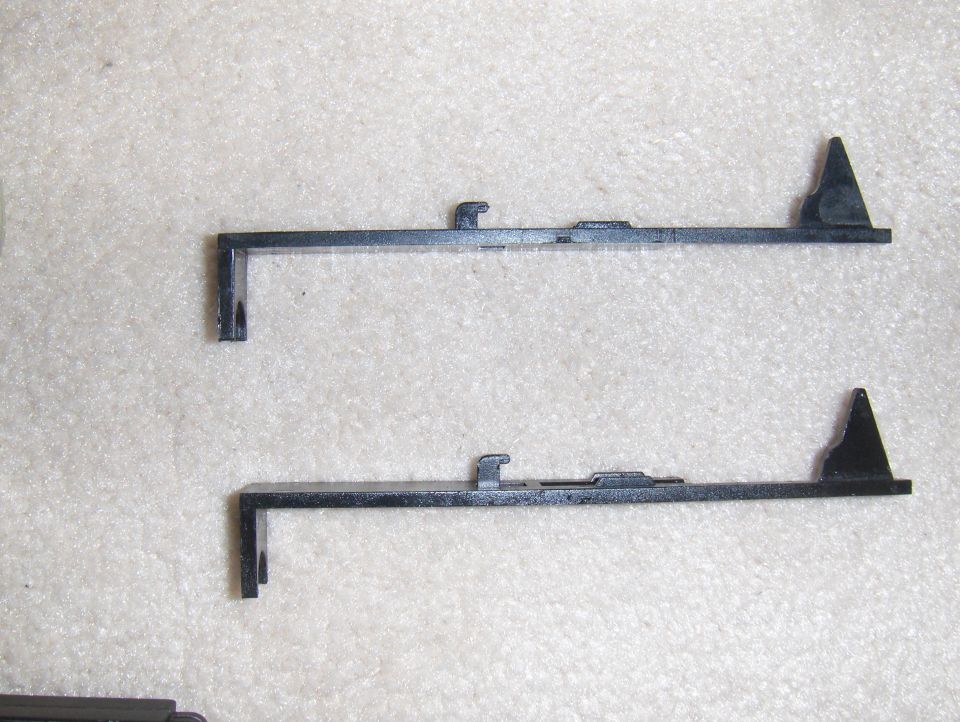 Two black plastic automotive trim pieces on a textured surface. A website URL is visible at the bottom right