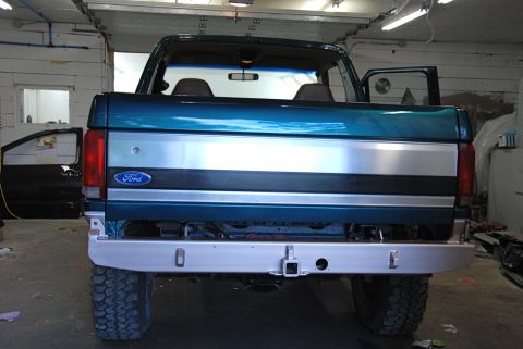 1996 Ford Bronco - The rear of a Ford Bronco is shown in a garage, with its doors open and a tow hitch installed.