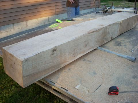 2000 Chevrolet Tahoe - A large, rough-cut wooden beam rests on a sawhorse, with a tape measure and Supermotors logo visible in the foreground.