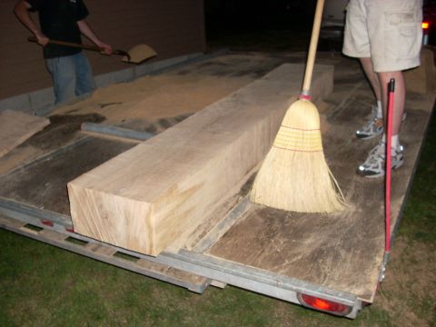 2000 Chevrolet Tahoe - A trailer is being cleaned of sawdust after loading a large wooden beam.