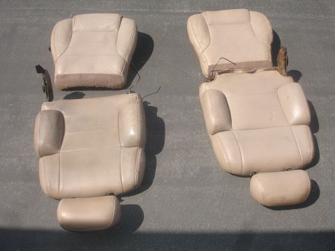 1993 Ford Taurus - Two tan leather car seats are laid out on a gray surface, showing their interior components and upholstery.