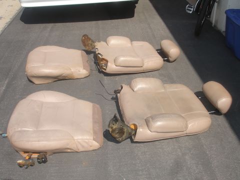 1993 Ford Taurus - Disassembled tan leather car seats, likely for repair or replacement, are shown on a paved surface.
