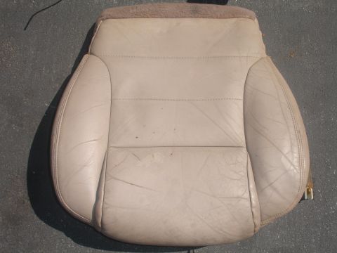 1993 Ford Taurus - A beige leather car seat, showing signs of age and use, is photographed from a top-down perspective.