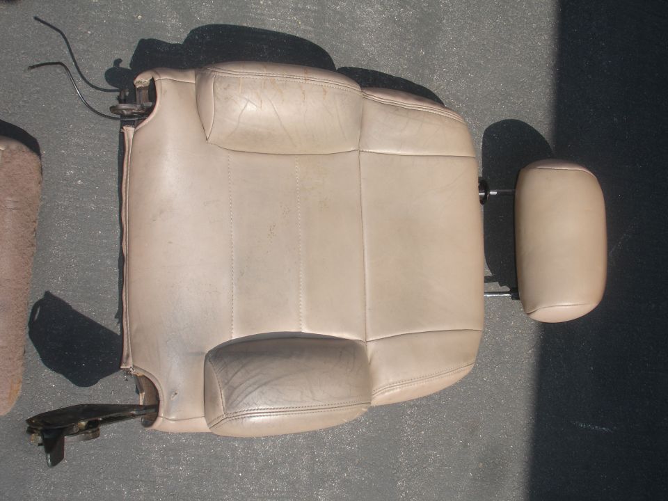 Tan leather car seat and headrest detached from vehicle