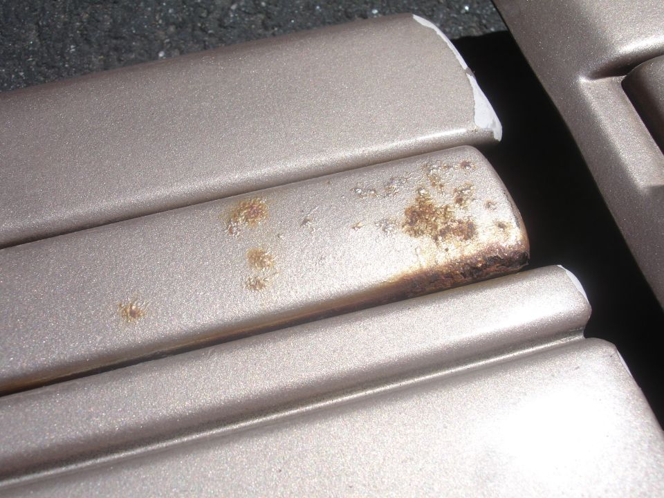 Close-up of car trim showing areas of rust and corrosion