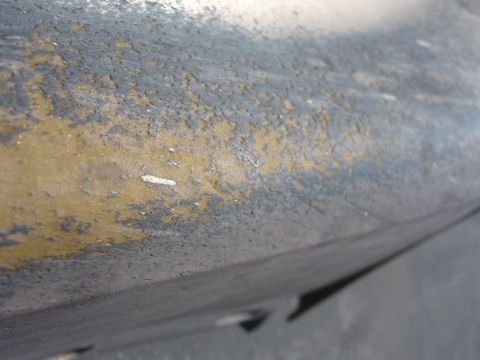 1993 Ford Taurus - Close-up of a car part showing significant paint degradation and peeling.