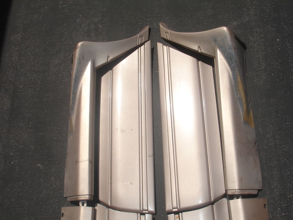 Two silver car bumper sections with vertical grooves and curved ends