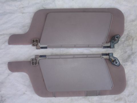 1993 Ford Taurus - A pair of car sun visors are shown, each with a hinged bracket for attachment.