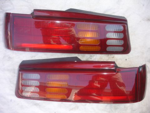 1993 Ford Taurus - Two red taillights, likely from a 1993 Ford Taurus, are shown side-by-side.
