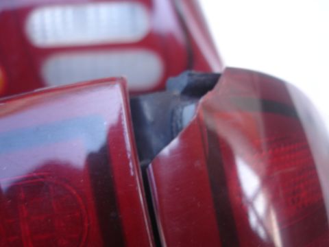 1993 Ford Taurus - Detail of adjacent red tail lights on a vehicle, with a visible gap and black trim piece.