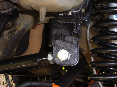 1993 Ford Bronco - Close-up view of aftermarket suspension components, including a bracket and a coil spring.