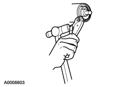 2007 Ford Mustang - Service manual line drawing showing a hand operating a tool during a repair step.
