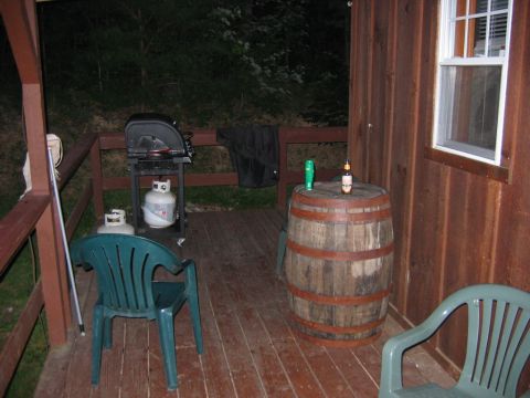 1985 Ford LTD Crown Victoria - A wooden deck scene includes a grill, propane tanks, chairs, and a barrel table with drinks.