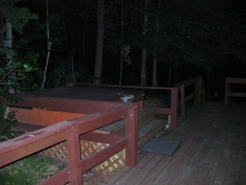 1985 Ford LTD Crown Victoria - A hot tub sits on a wooden deck at night, with trees in the background.