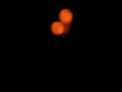 1985 Ford LTD Crown Victoria - The image shows two blurred orange circles against a black background, with a small blue dot below them.