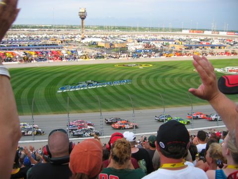1985 Ford LTD Crown Victoria - View from the grandstands at Chicagoland Speedway during a 2008 NASCAR race, showing a pack of stock cars including the orange No. 20 and N…