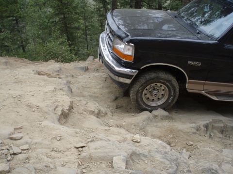 1996 Ford Bronco - A black Ford Bronco navigates a challenging rocky path.