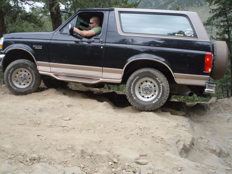 Black 1996 Ford Bronco side view on rocky trail